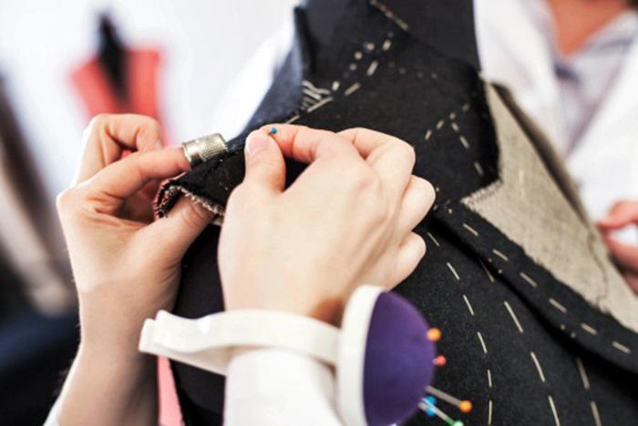 Dressmaker pinning fabric to mannequin