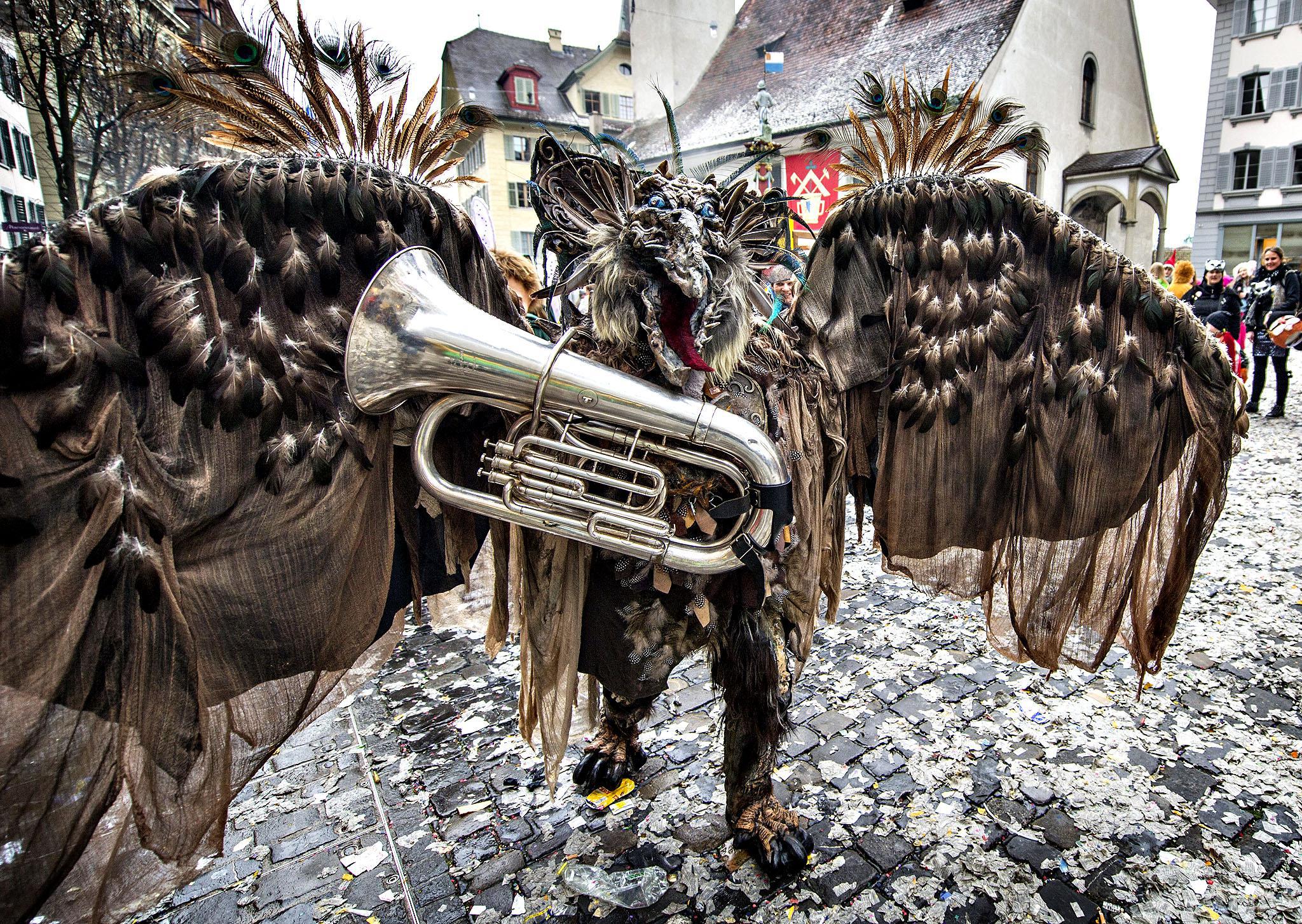 A reveler in a carnival costume attends the opening of the Lucer